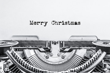 Merry Christmas text typed on a vintage typewriter, black ink on old paper.