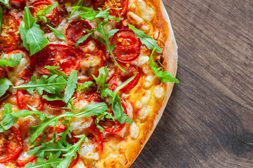 vegetarian Pizza with Mozzarella cheese, Tomatoes, pepper, Spices and Fresh arugula. Italian pizza. Pizza Margherita or Margarita on wooden table background