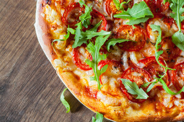 vegetarian Pizza with Mozzarella cheese, Tomatoes, pepper, Spices and Fresh arugula. Italian pizza. Pizza Margherita or Margarita on wooden table background