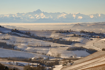 Snowy landscape with hills and alpine mountains in winter, Langhe, Piedmont, Italy