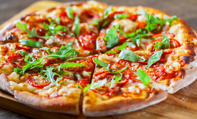 vegetarian Pizza with Mozzarella cheese, Tomatoes, pepper, Spices and Fresh arugula. Italian pizza. Pizza Margherita or Margarita on wooden table background