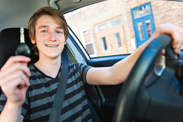 A Teenage boy and new driver behind wheel of his car