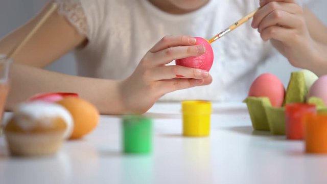 Child painting color eggs brush, decorating Easter symbol, preparation festival