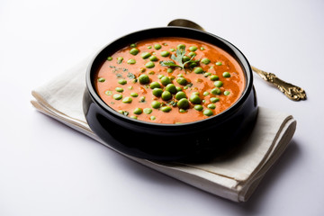 Green Peas curry / Matar masala served in a bowl over moody background. selective focus