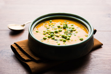 Green Peas curry / Matar masala served in a bowl over moody background. selective focus