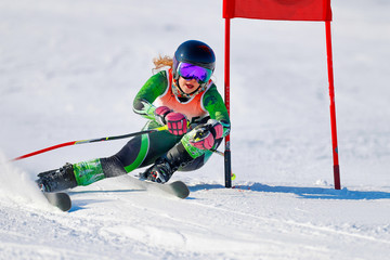 An alpine skier at a gate during a giant slalom race.