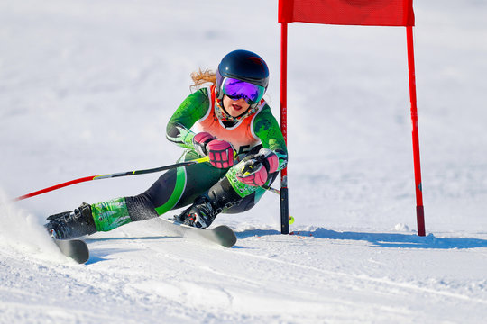 An alpine skier at a gate during a giant slalom race.