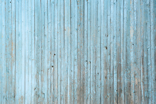 Wall of blue wooden slats. Exfoliated blue paint. Vertical laying, upright