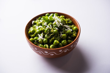 Green peas dry recipe or matar ki sookhi sabji, served in a serving pan or terracotta bowl. Selective focus