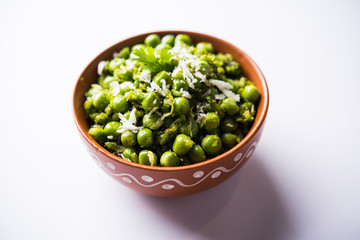 Green peas dry recipe or matar ki sookhi sabji, served in a serving pan or terracotta bowl. Selective focus