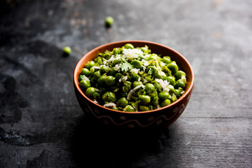 Green peas dry recipe or matar ki sookhi sabji, served in a serving pan or terracotta bowl. Selective focus