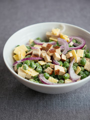 Vegan pea salad. Ingredients: garden peas, vegan (non-dairy) cheese, smokey tofu pieces, red onion, non-dairy yogurt, salt, pepper, vinegar