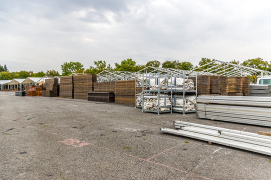 Messebau einer Regionalmesse, Zeltaufbau, Holzpfosten und Holzbretter f&uuml;r Zeltboden auf dem Stapel, im Hintergrund Zelte im Aufbau, Aluminiumprofile und weitere Elemente