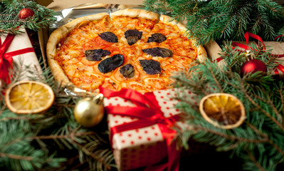 Fototapeta na wymiar pizza with Christmas decorations, gift, spruce, toys