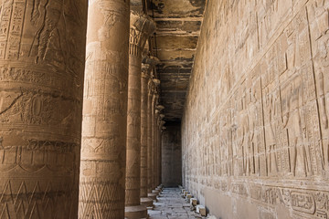 Hieroglyphic carvings on an ancient egyptian temple wall with columns