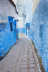 long narrow street in blue city in Morocco