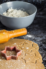 Cooking Christmas gingerbread cookies with ingredients on a dark background