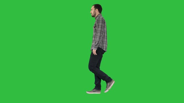 Young casual man walking on a Green Screen, Chroma Key.
