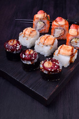Sushi rolls assortment on a black board