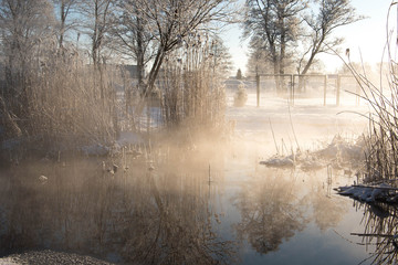 Steaming river in extremely cold and snowy winter morning 