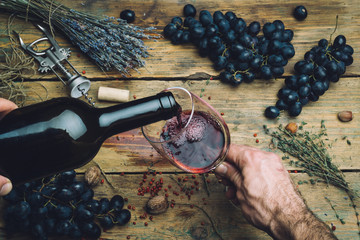 Wine maker pouring red wine (bio) for tasting. Red wine tasting (bio wine) in a wine glass with...