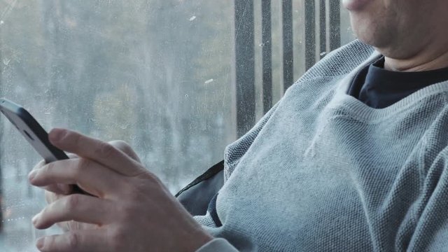 close up middle aged man uses a smartphone. He is studying various programs