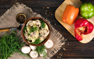 Potatoes with mushrooms on a wooden background