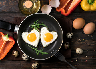 Fried eggs on a skillet on a wooden background