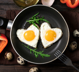 Fried eggs on a skillet on a wooden background
