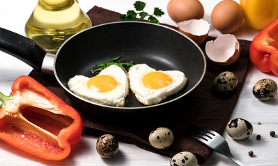 Fried eggs on a skillet on a wooden background