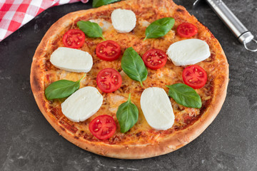 Pizza, food, vegetable, margarita.  Vegetables, mushrooms and tomatoes pizza on a black wooden background. It can be used as a background
