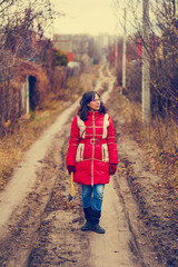 Fototapeta premium strong woman with hatchet standing on a rural road