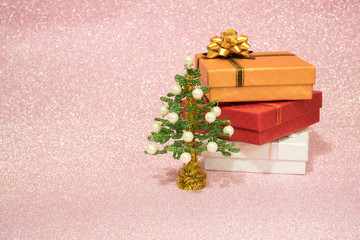 green Christmas tree of beads, followed by three gift boxes on a brilliant pink background with a place for an inscription