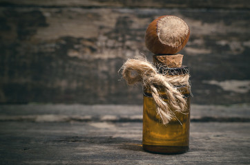 Hazelnut nut oil in the bottle on the wooden table background.