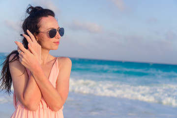 Young happy woman in dress on white beach