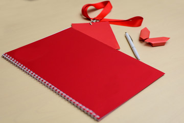 Red notebook, pen and badge on a table. Business meeting