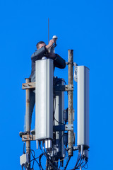 Technician working on cellular tower