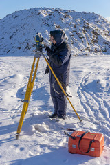 A surveyor enters the survey data for a cadastre at a construction site during the winter period.