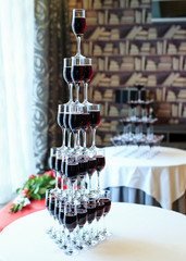 Waiter pouring red wine or champagne into glasses for party.