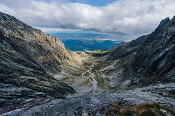 View of a Skalnate pleso lake in High Tatras (Vysoke Tatry), Slovensko. Deep alpine like valley in mountain landscape of Vysoke Tatry. Skalnate pleso and a cable car lift to Lomnicky stit.