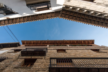 Fototapeta na wymiar Wooden eaves of houses nearby in an old village of Spain, carved wood carving low angle shooting blue sky and clouds views, traditional architecture building