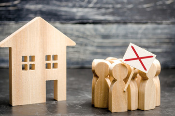A crowd of people protests against the rising prices and cost of services near a wooden house....