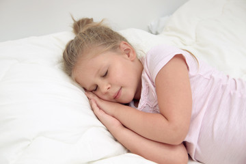 Fototapeta na wymiar Little girl sleeping blissfully in bed