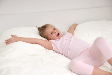 Obraz na płótnie Canvas Little girl iwaking up in bed