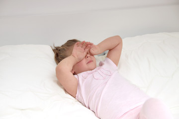 Little girl iwaking up in bed