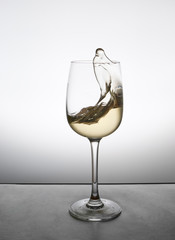 splash of white wine in a glass