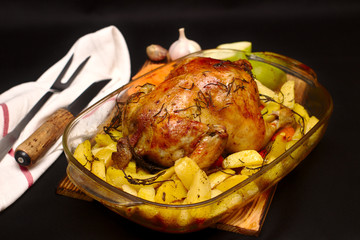 baked chicken with a crispy crust on a baking sheet in a dark oven
