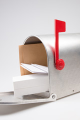 silver metal mailbox open with mails and package