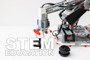 Concept of STEM education. Robot hand is on the background. Inscription 