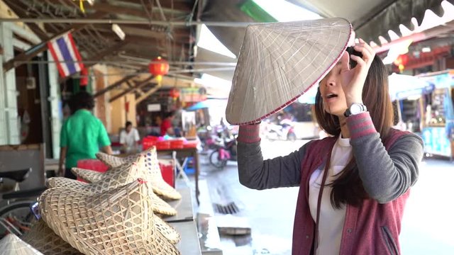 Woman tourist is wearing (Vietnamese Hat) 